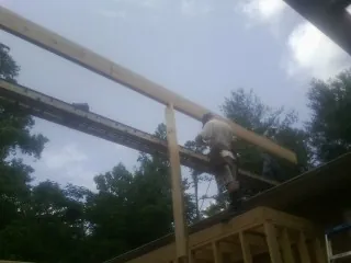 Carpenter setting a ridge beam over a new addition frame — Ice Dam Removal by Roofing Brothers in Loon Lake