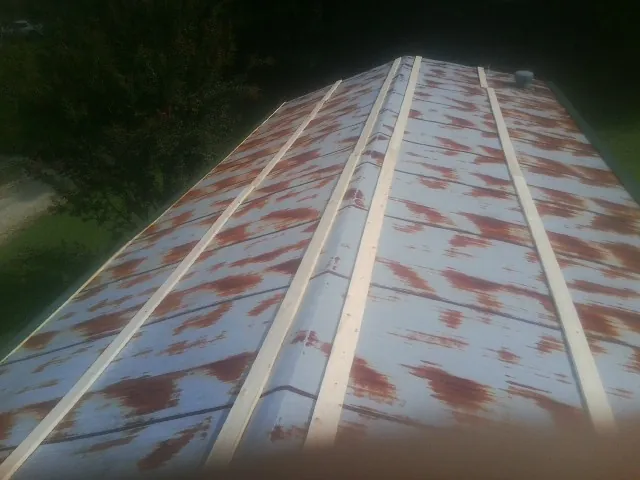 Rusted metal roof panels with new wood purlins before replacement — Storm Damage Roof Repair in Loon Lake by Roofing Brothers